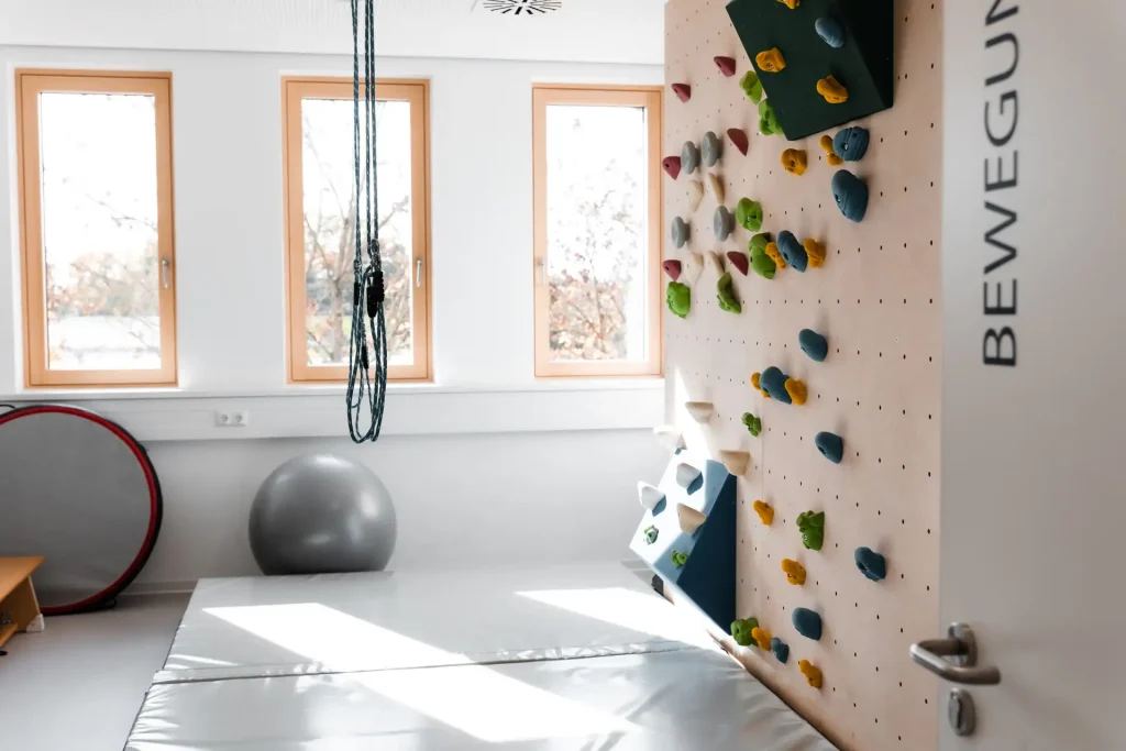 Bewegungsraum mit einer Kletterwand, Gymnastikball und weiteren Therapiegeräten für physiotherapeutische Übungen im Therapie Zentrum Augsburg.